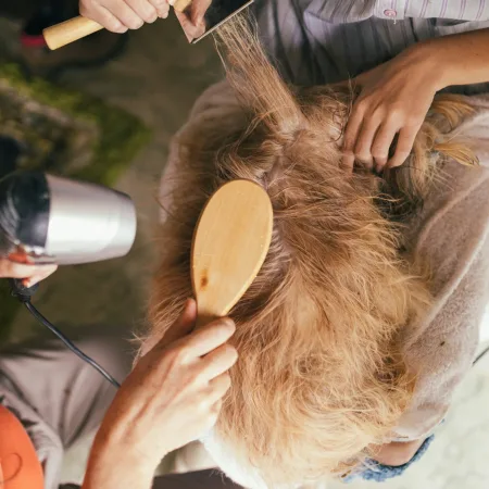 person pouring water on womans hair